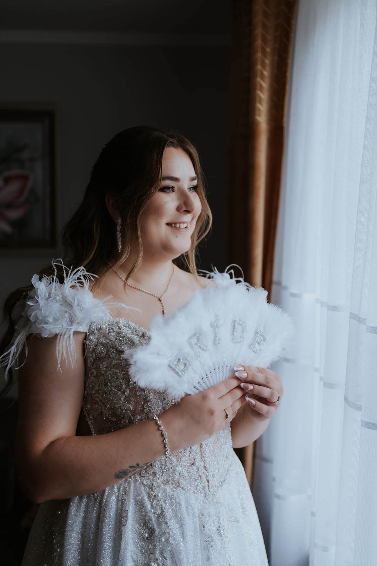 Patrycja, Panna Młoda, przy oknie w sukni ślubnej przed ceremonią